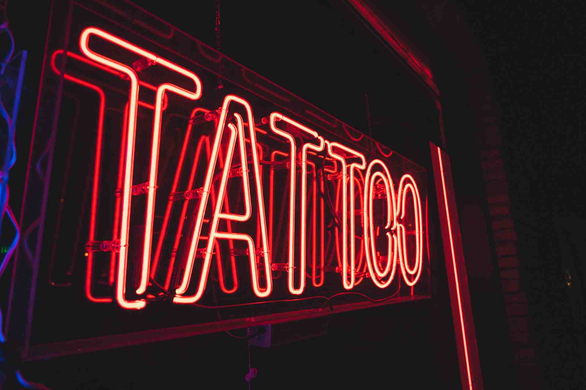 Neon z napisem tatuaż